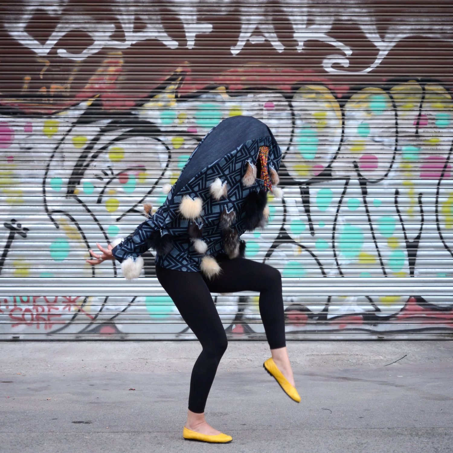 Performer crouching and moving while wearing the sculptural Batuque garment