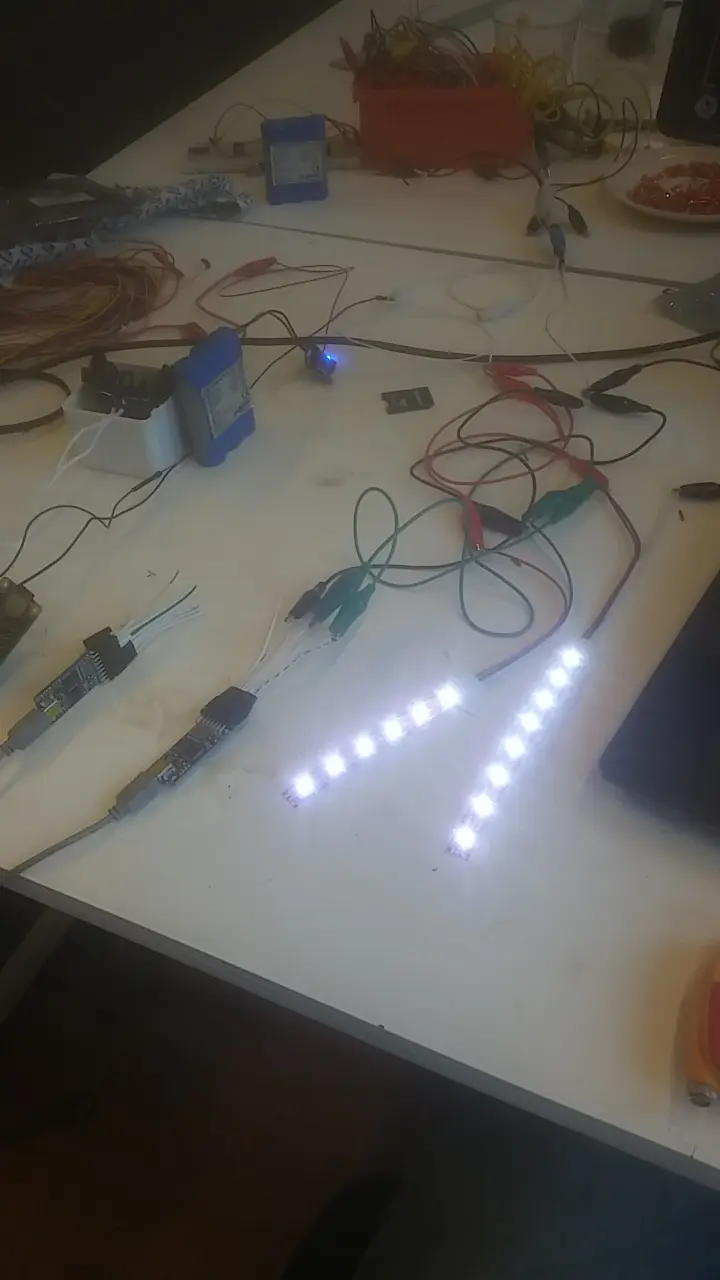 Illuminated LED strip and electronic components being tested on a worktable