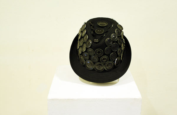 The black Mind Taipei speaker-covered hat displayed on a white plinth