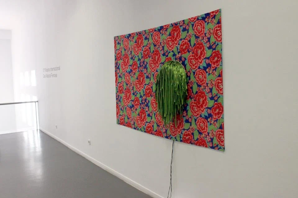 Multipodiforme Verde installed on a large floral textile panel in a white gallery