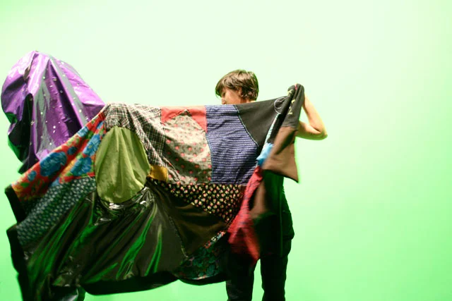 Performers extending the red and blue Parangonet capes during a live performance