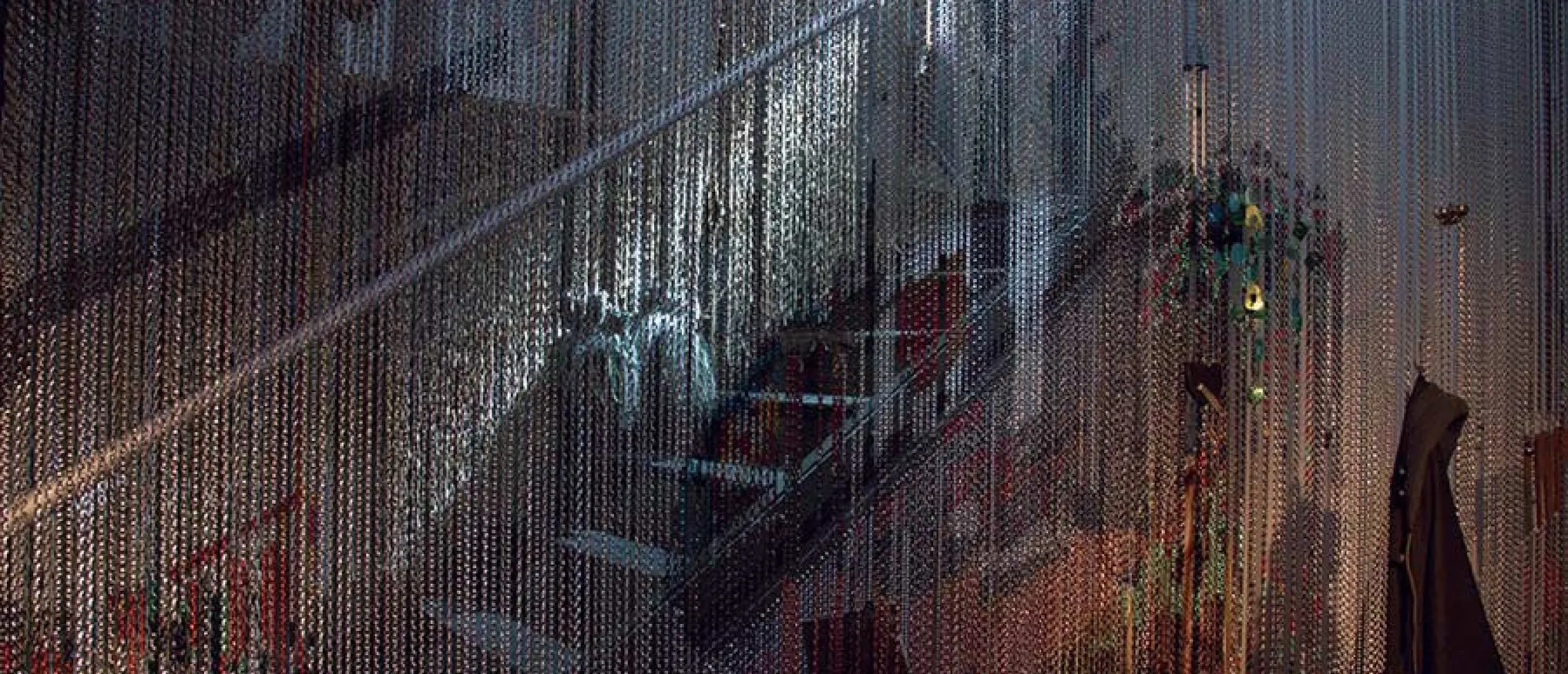 Sonic Fabric installation view with a staircase surrounded by hanging metal and textile elements