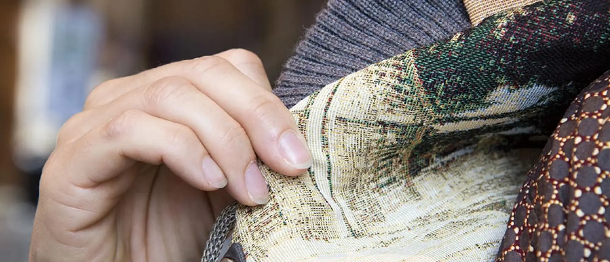 Close view of a visitor manipulating one of the Orchestra Scarf closures